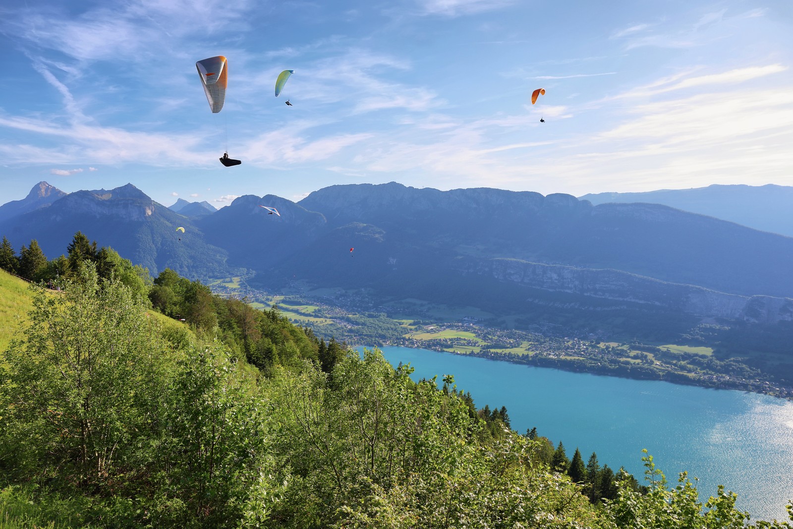Paragliders soaring above Lake Annecy, France.