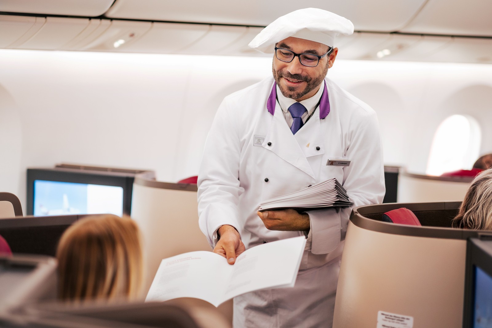 Austrian Airlines Flying Chef presenting gourmet menus in Business Class on a long-haul flight. Photo by Austrian Airlines.