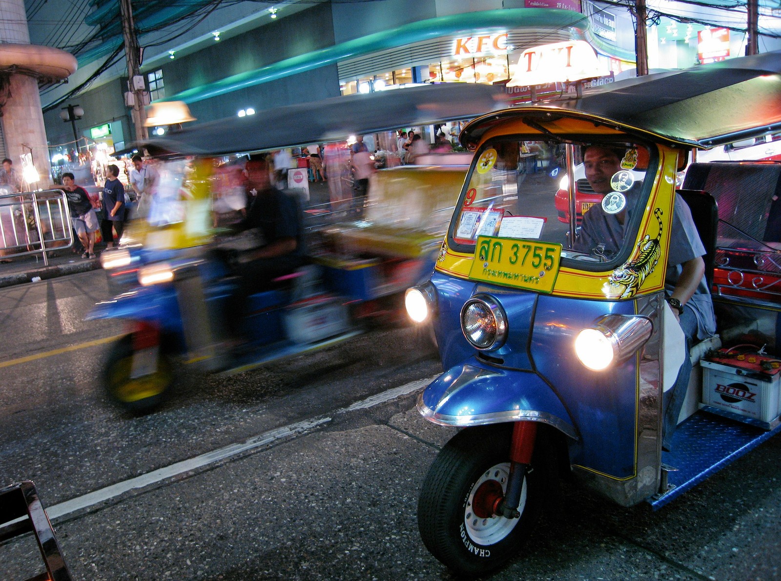 A classic tuk-tuk speeds through glowing city streets, capturing the energy of urban Bangkok, Thailand. Photo by Tsion Chudnovsky.