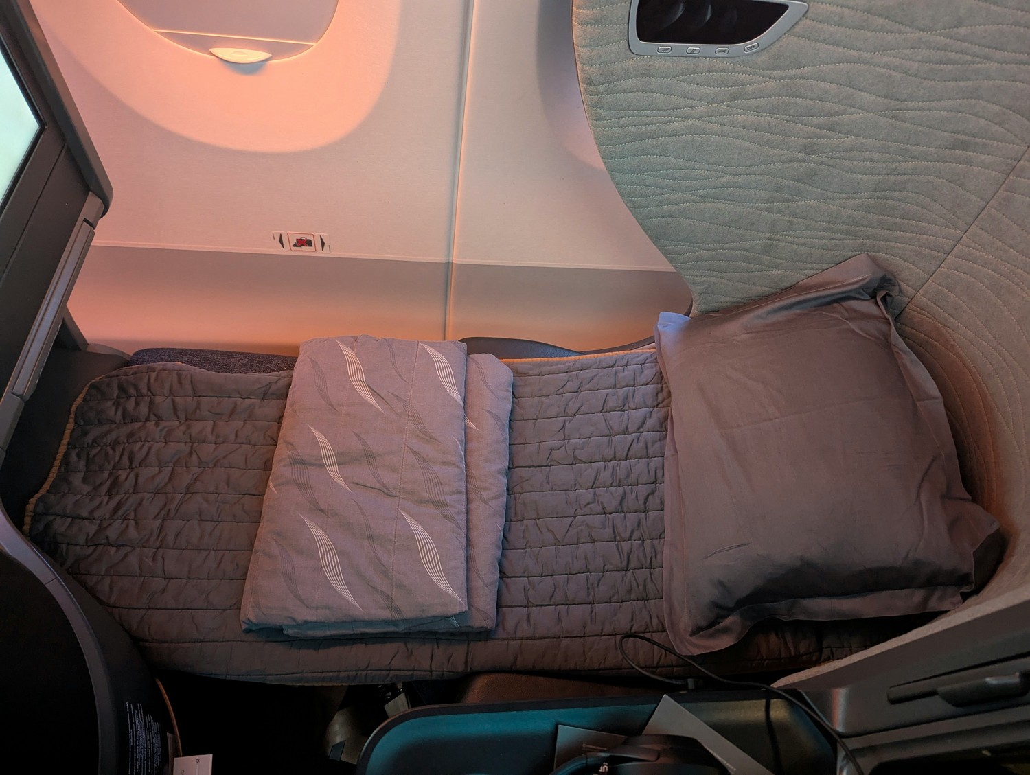 Lie-flat bed setup in Turkish Airlines Business Class with full bedding, pillow, and duvet prepared for overnight long-haul flights. Photo by Frugal Flyer.